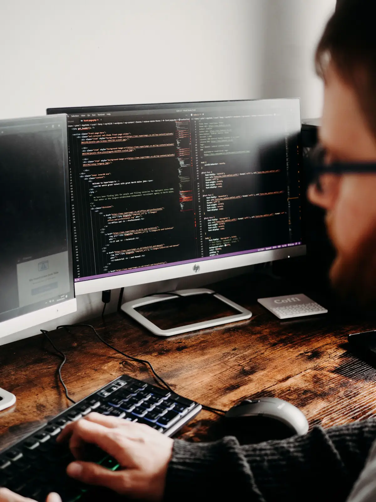 Software developer working at a desk with multiple monitors